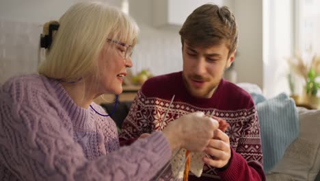 grandson teaching grandmother how to knit
