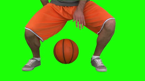 -Hombre-Regateando-Una-Pelota-De-Baloncesto-Contra-El-Fondo-Verde