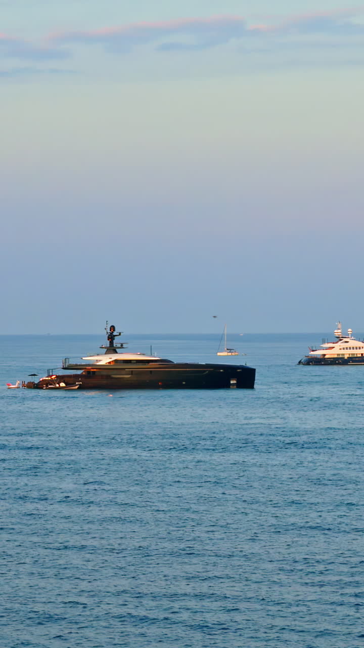 Multiple boats moving on the sea in Antibes, France at sunset. Vertical