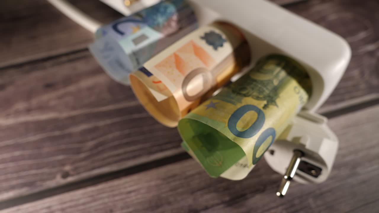 Closeup shot of currency inside of an electrical socket.High prices concept.