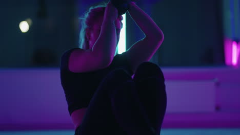 woman is doing exercises with hammock for antigravity yoga in fitness hall training alone in gym