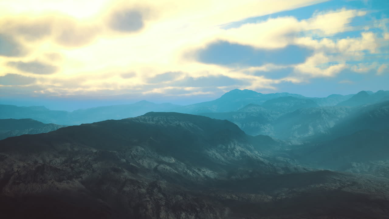 Stunning landscape of mountains under a dramatic sunset sky in soft hues