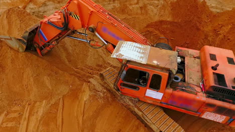 Orangefarbener-Raupenbagger-Steht-Auf-Sandmine.-Bergbaubagger