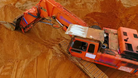 excavadora de rastreo naranja de pie en la mina de arena. excavadora de minería