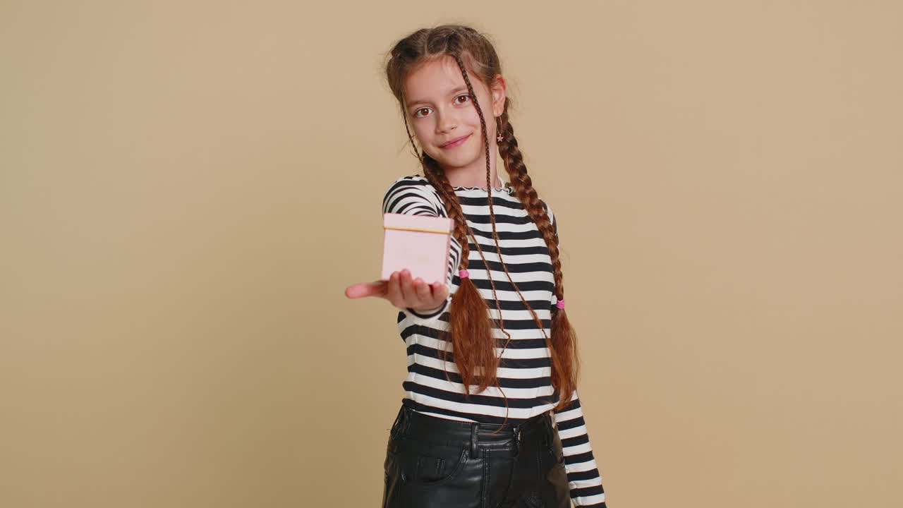 encantadora sonrisa preadolescente niño niña niño presentando joyas caja de regalo oferta envuelto presente celebrando