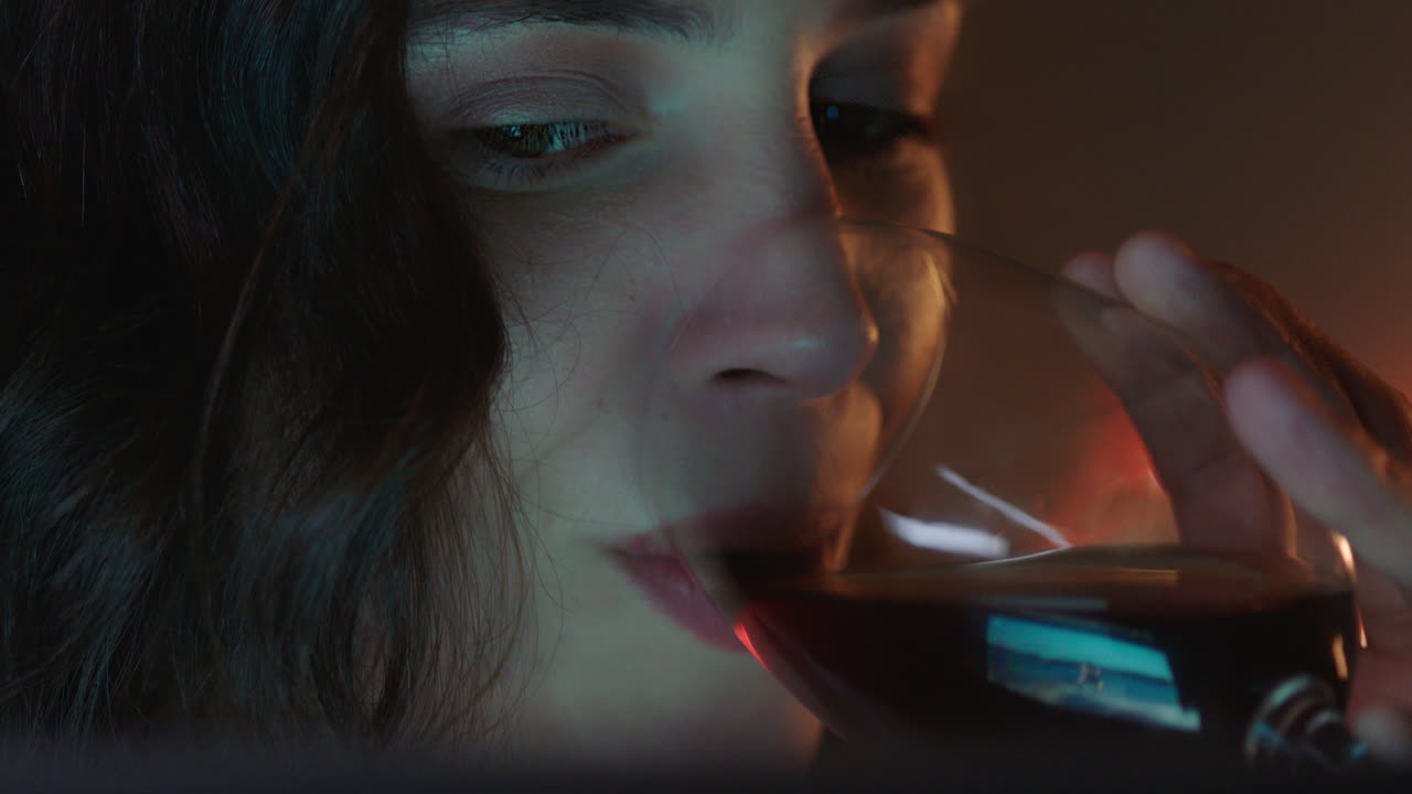 retrato de cerca mujer atractiva usando una tableta viendo una película por la noche bebiendo vino disfrutando del entretenimiento
