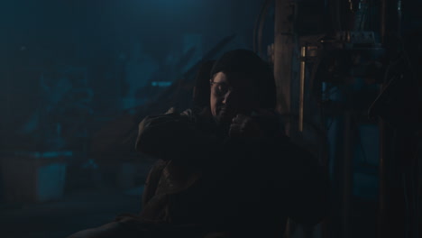 mysterious man in the workshop at night smokes a cigarette