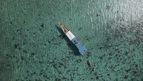 top view of a wooden boat at the blue water of indonesian coast in labuan bajo village