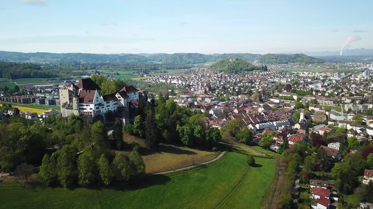 Stunning Lenzburg Castle standing on the almost circular hill rising 100 m over the surrounding plain and town Aargau canton, Switzerland, orbiting shot