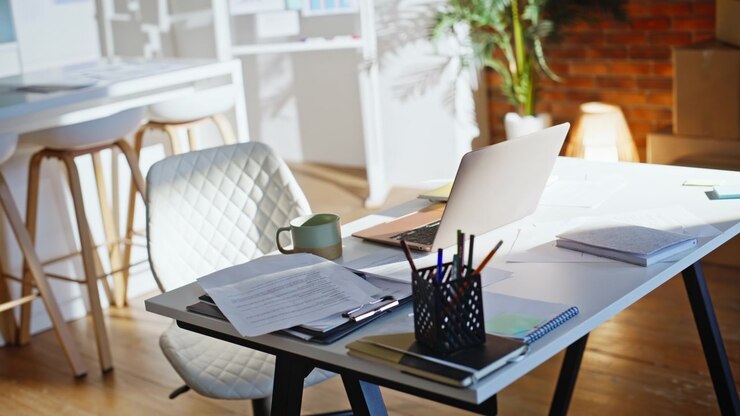 Local de trabalho moderno com laptop, documentos e caneca de café. Interior de loft sem pessoas
