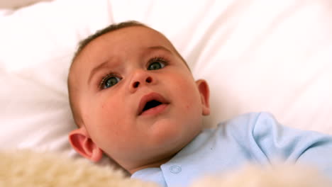 cute baby on a bed with teddy bear