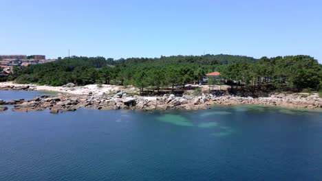 Dichter-Wald-An-Felsiger-Küste-Mit-Klarem-Smaragdgrünem-Wasser-In-Sanxenxo,-Spanien