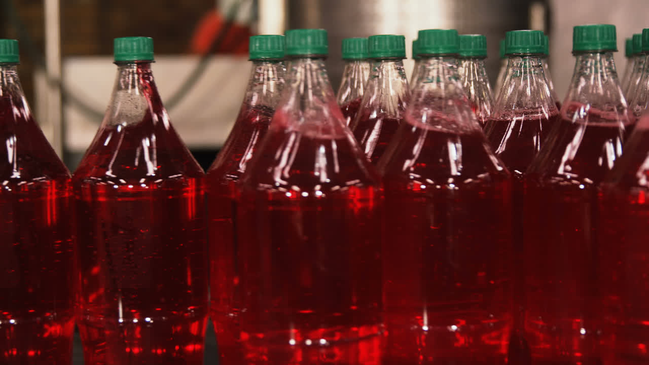 탄산 음료 병이 컨베이어에서 움직이고 있습니다.