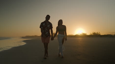 una pareja linda caminando por la playa.