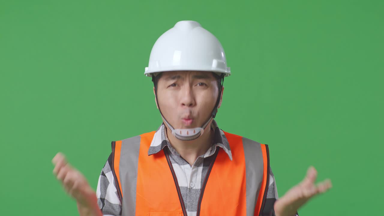 Close Up Of Wondering Asian Male Engineer With Safety Helmet Saying Why Working Doubtfully In The Green Screen Background Studio