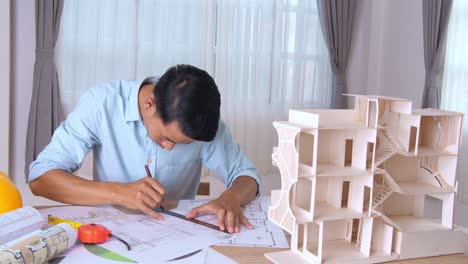 architect working with architectural house model