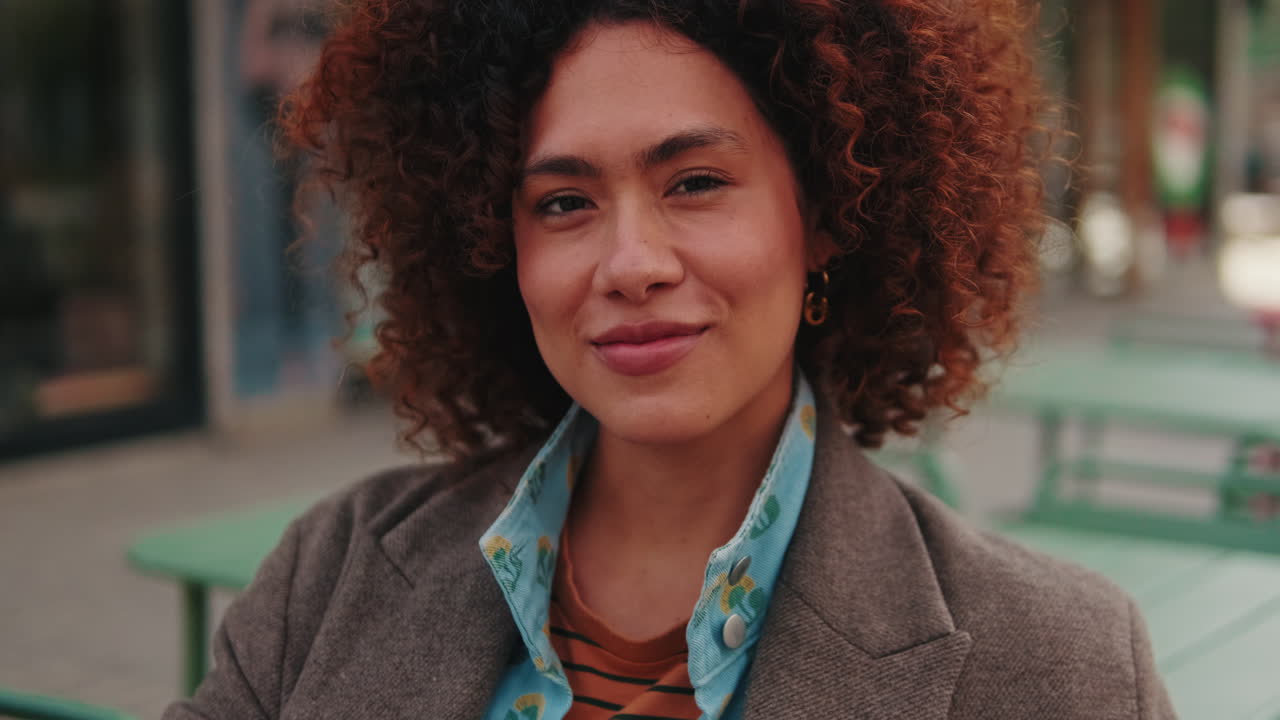 Portrait of Happy Young Woman in City Cafe