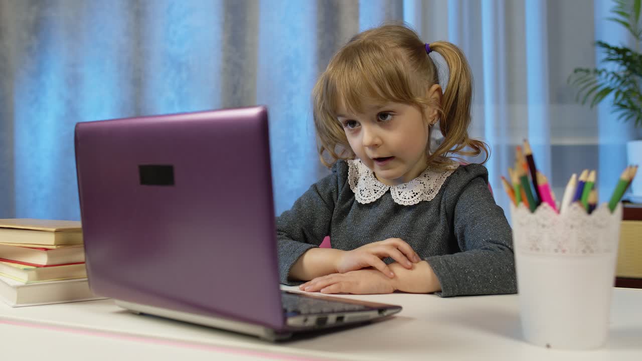 niña escolar aprendiendo lecciones, educación a distancia en casa sentada en la mesa usando una computadora portátil