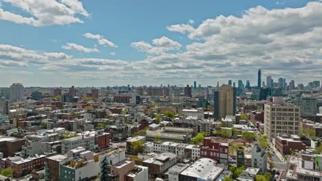 un avión no tripulado sobrevuela un barrio estadounidense en brooklyn y un rascacielos en el fondo durante un día soleado - nueva york, estados unidos