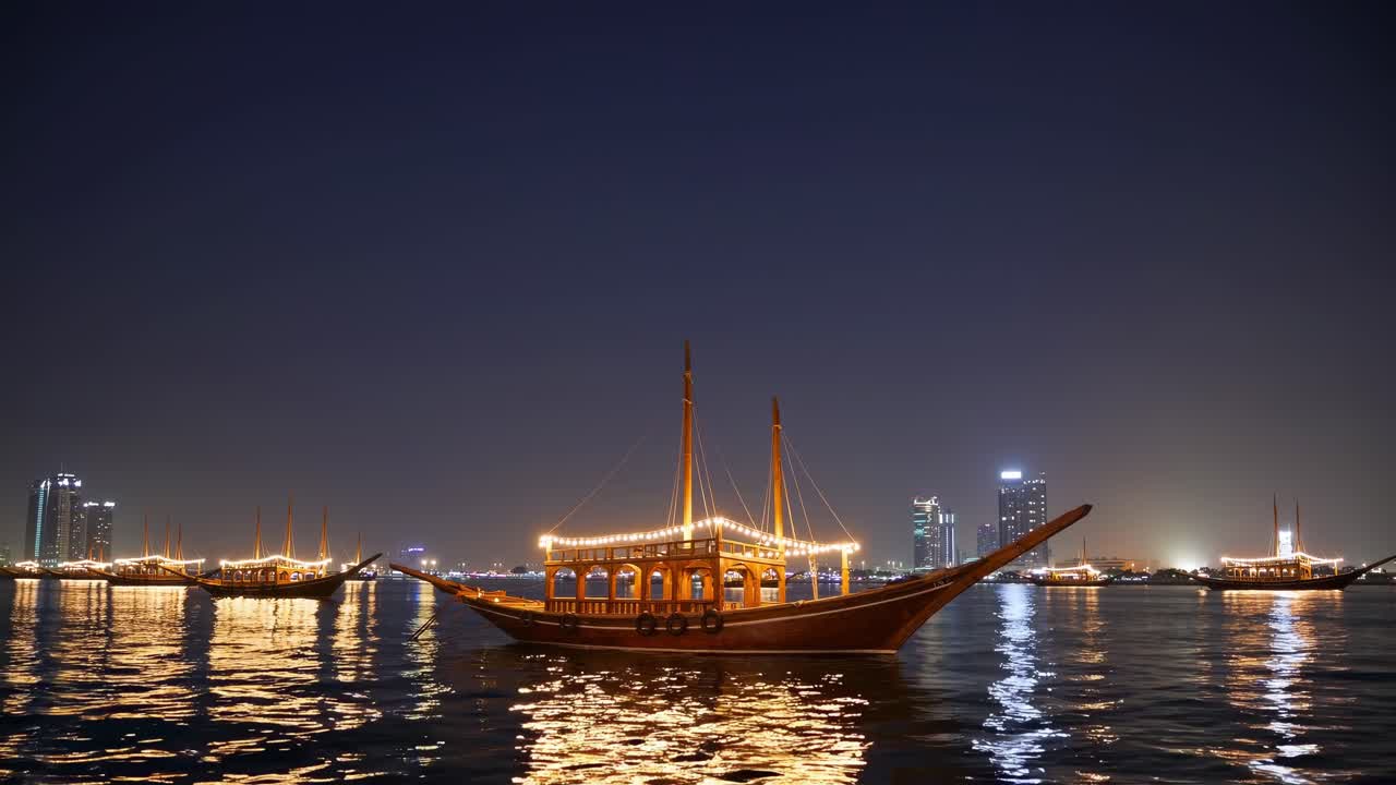 Traditional wooden dhow decorated with lights floating serenely on Dubai Creek at night, illuminated buildings and other dhows visible in the background, creating a magical and tranquil atmosphere