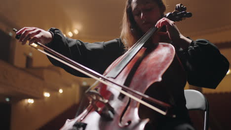 talented violoncellist is playing cello on scene of music hall lady and violoncello in orchestra