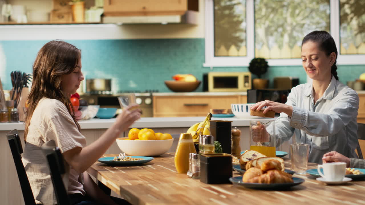 família reunida ao redor da mesa da cozinha para um café da manhã farto