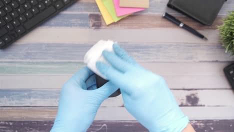 cleaning a computer mouse with gloves