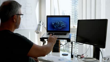 Man-working-on-laptop-on-desk-4k