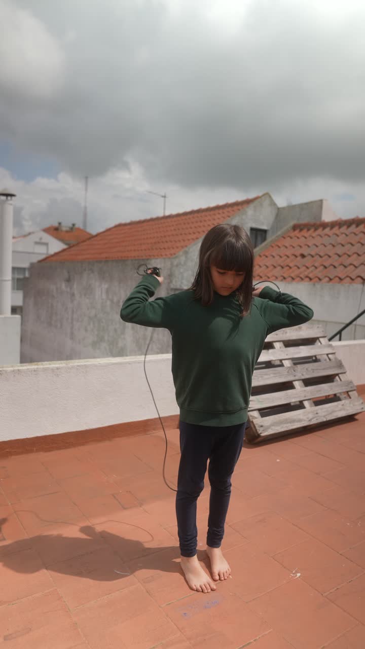 Child skipping rope on a rooftop
