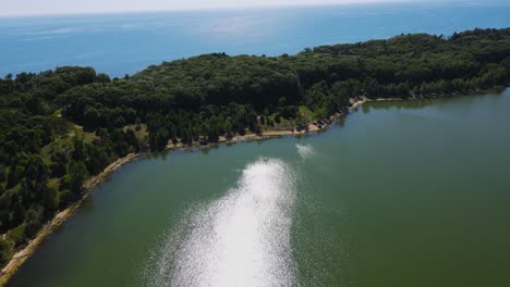 subiendo y panoramizando para mostrar el lago michigan sobre el lago en el puerto de dunas