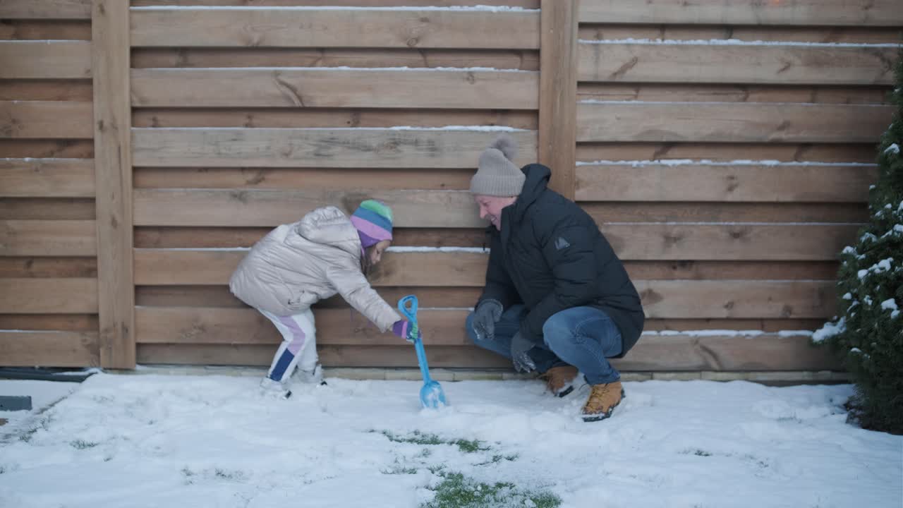 abuelo y nieta divirtiéndose en la nieve