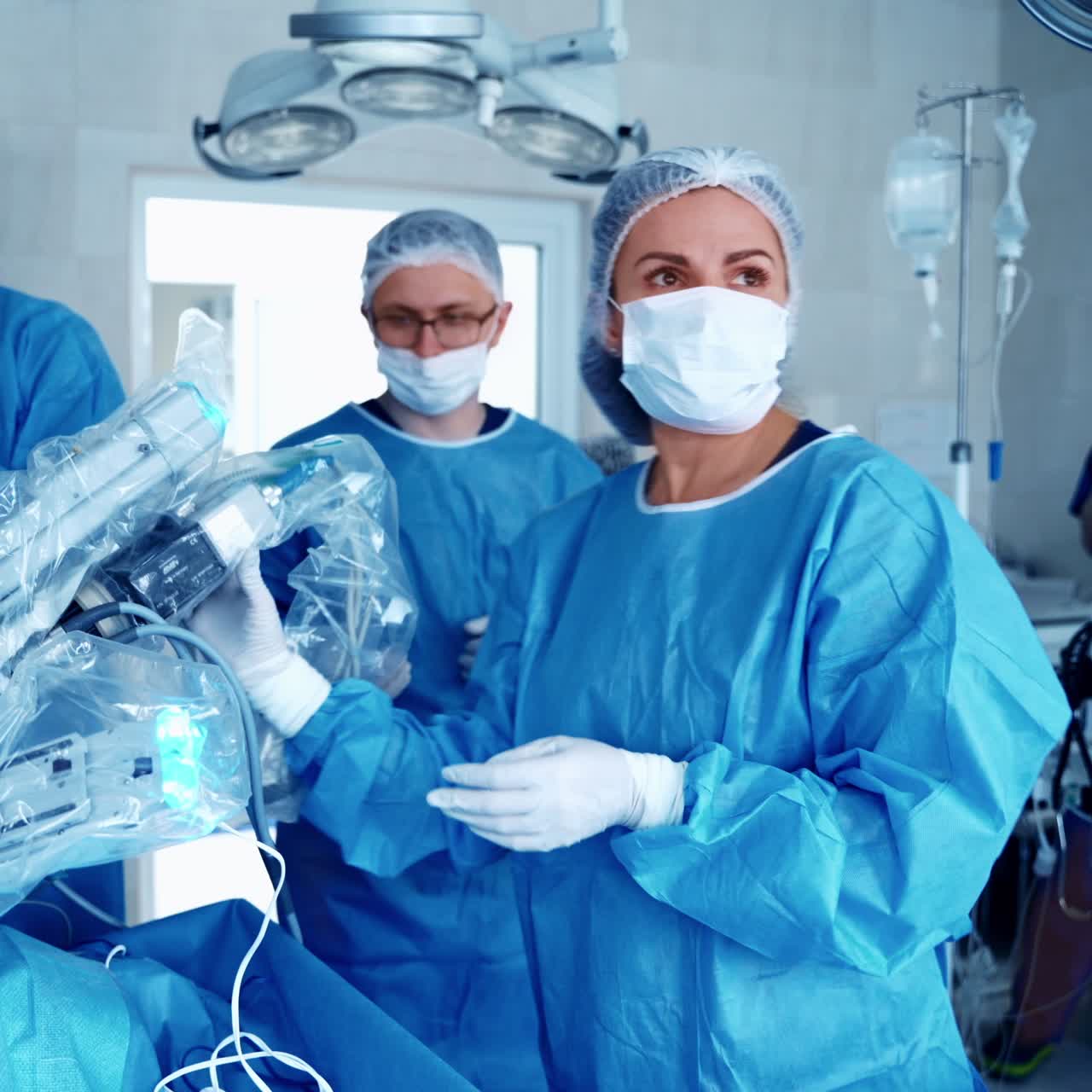 Operating room. Medical surgical robot doing operation. Medical workers near modern equipment in clinic. Minimally invasive robotic surgery.