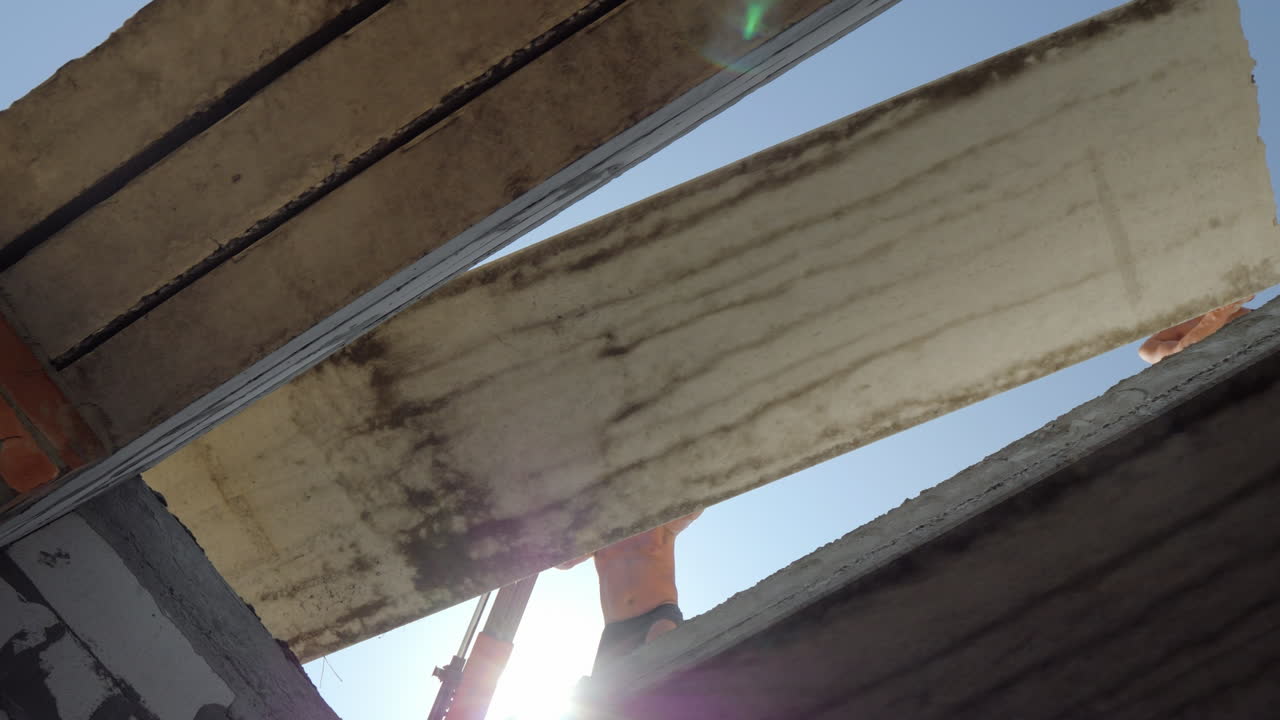 노동자들은 바닥의 무거운 철근 콘크리트 부분을 건설 현장에서 열심히 설치합니다.