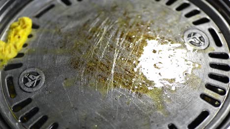 a chef using tong, putting butter on the grilling pan for squid and marinated meat -closeup shot