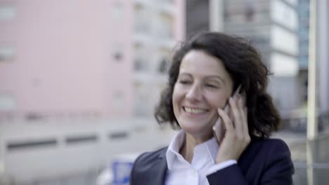 mujer de negocios alegre hablando por teléfono inteligente