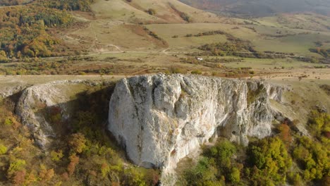 Aerial-panning-high-angle-shot-of-big-high-rock-on-the-edge-of-a-mountain-5