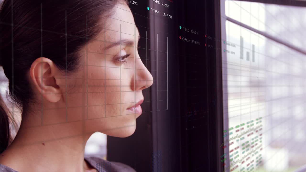 Female analyst standing by window, watching finance charts appearing on glass, informing decisions