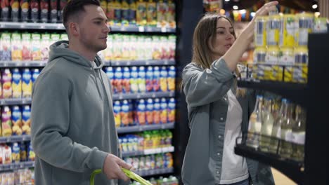 Couple-in-the-grocery-store.-The-girl-chooses-what-she-wants-to-buy.-Daily