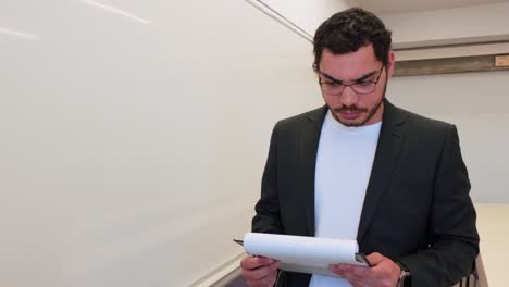 man writing a formula in a lecture hall