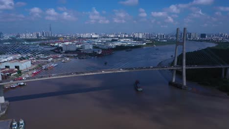 Aerial-view-of-Phu-My-Bridge-over-Saigon-river-with-road-and-river-transportation-on-a-sunny-day