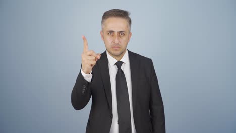 businessman alerting camera with stern expression.