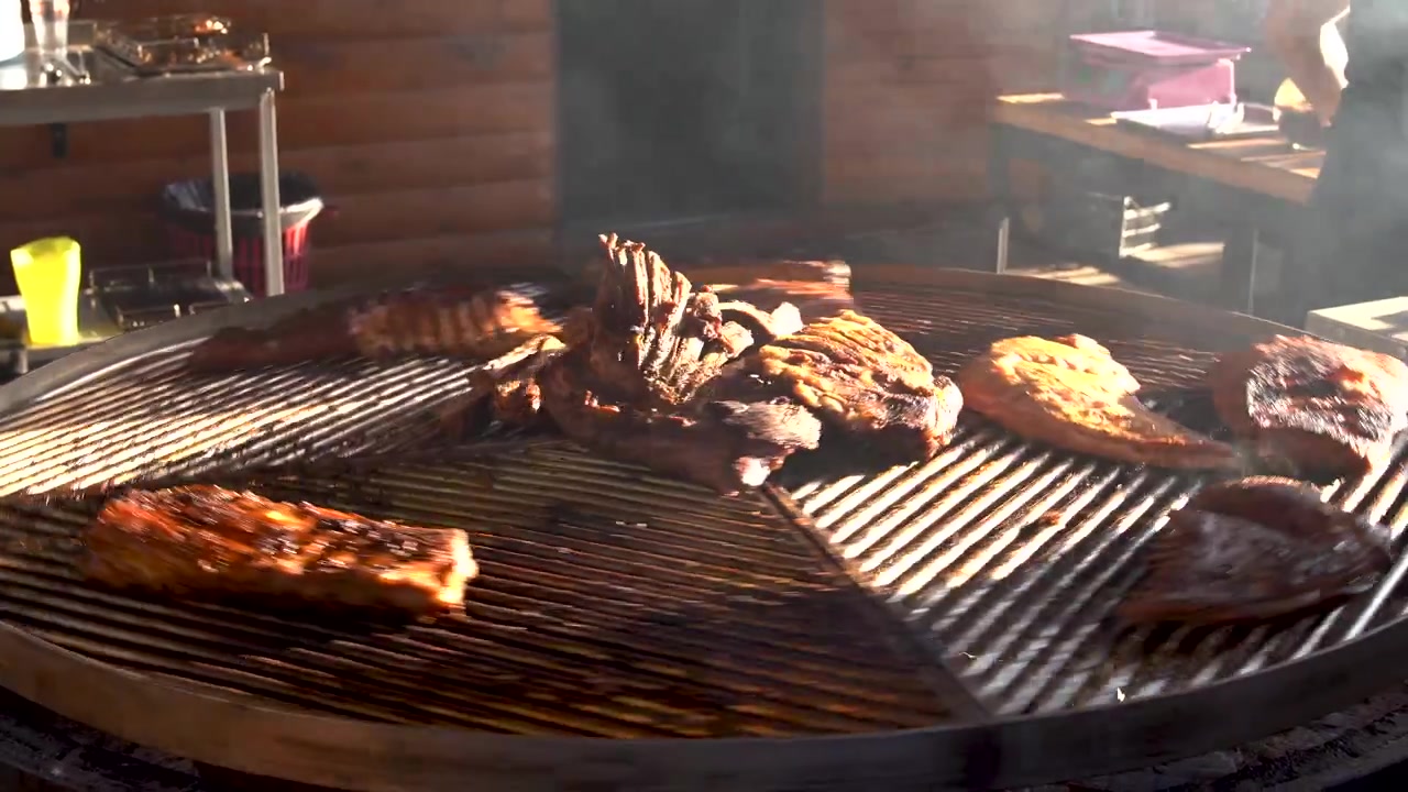 Grandi tagli di carne e costine alla griglia su un barbecue rotondo