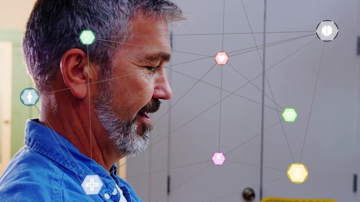Mature man typing on IT device for work, activating AR nodes clustering ear wrist, camera advancing