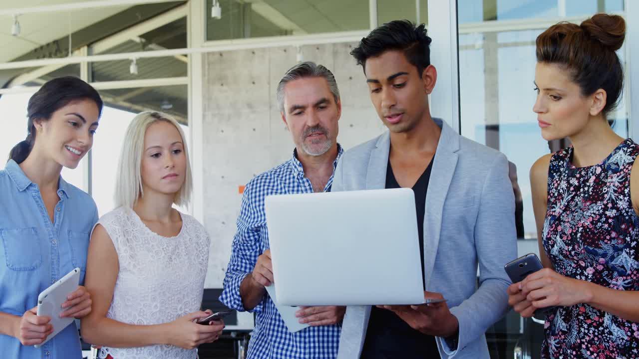 ejecutivos de negocios discutiendo sobre una computadora portátil 4k