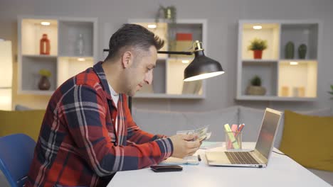 el hombre que ve la cuenta de dinero en su computadora portátil.