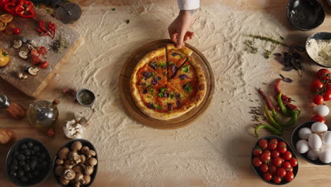 chef taking pizza slice on kitchen cutting board. delicious italian food concept