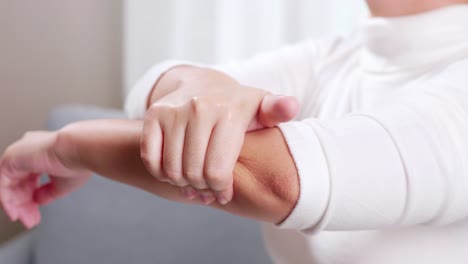 Young-woman-having-pain-in-her-elbow-and-using-hand-for-self-massage-to-relieve-aches-and-pains