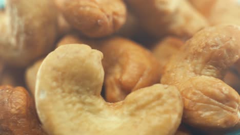 a macro close up shot of a roasted salty cashew bawl on a rotating stand, slow motion, 4k