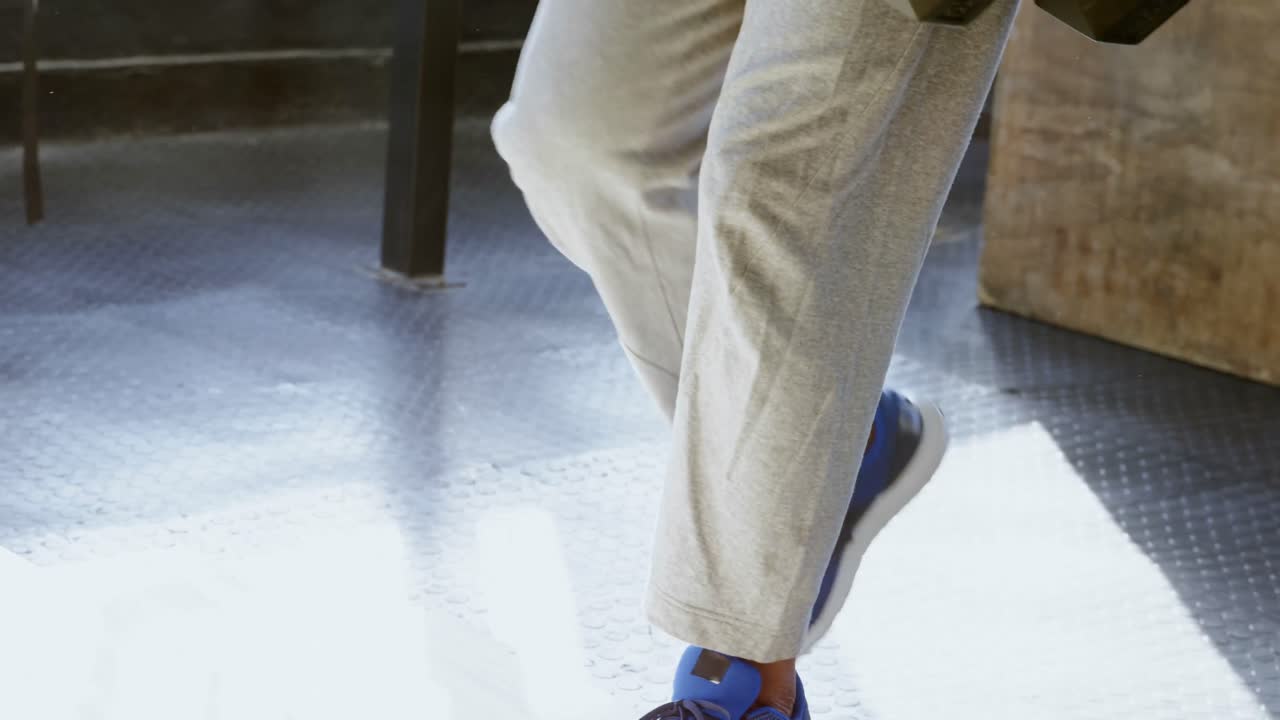 피트니스 스튜디오 4k에서 덤벨로 운동하는 고령 남성