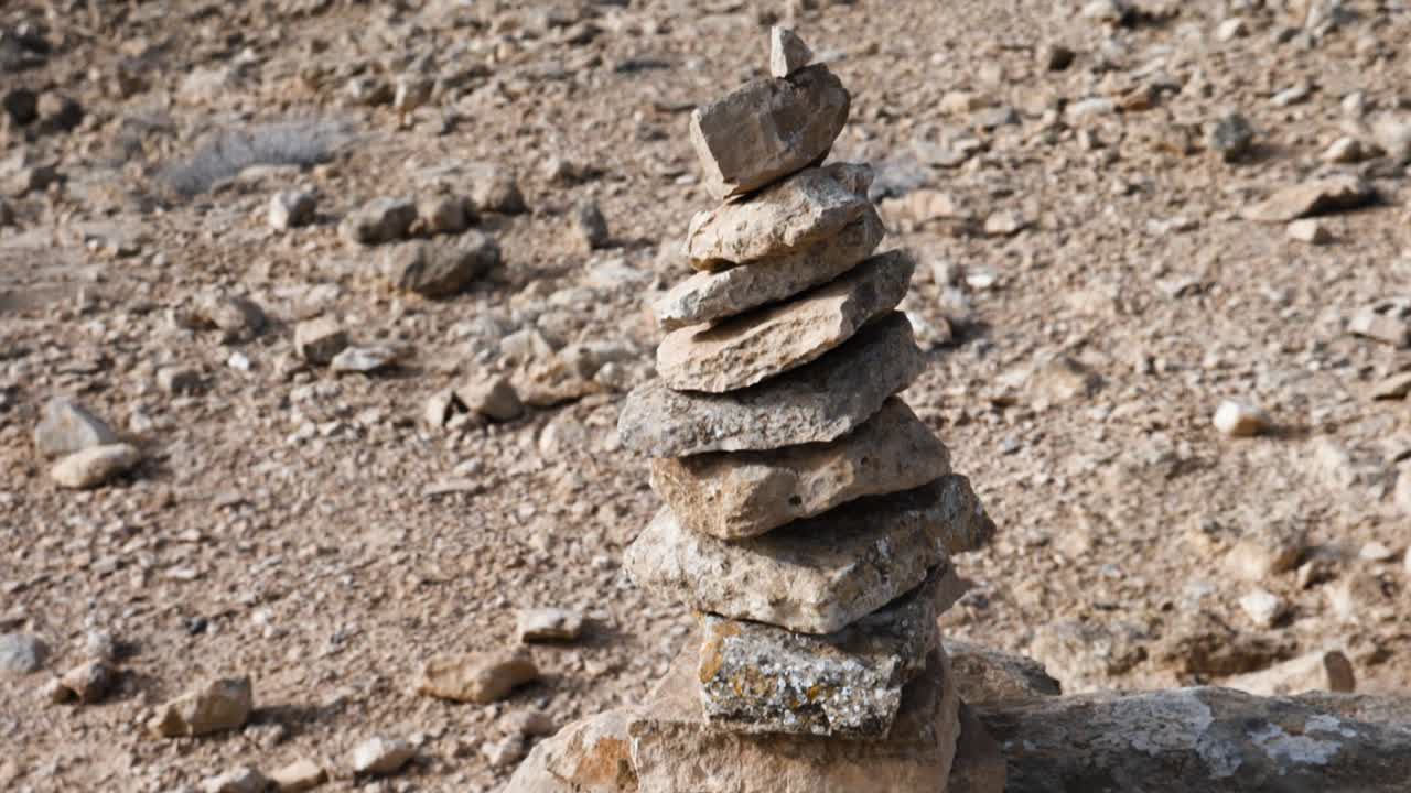 뒤에 있는 불모의 풍경을 드러내기 위해 원추형 돌 케른의 근접 촬영